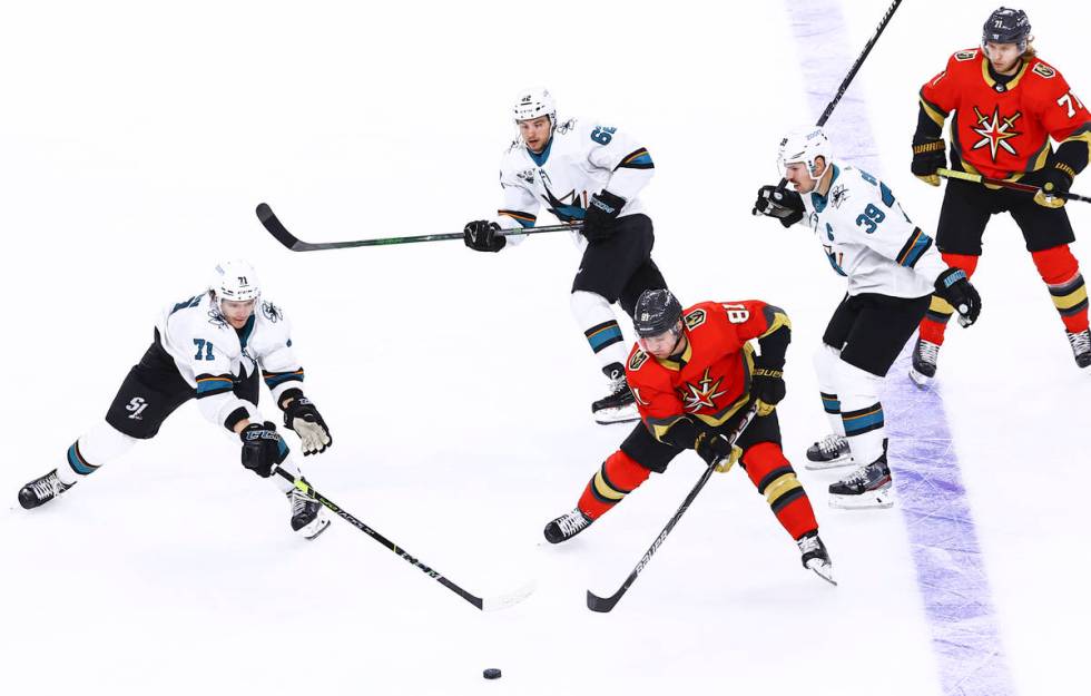 San Jose Sharks' Nikolai Knyzhov (71) and Golden Knights' Jonathan Marchessault (81) reach for ...