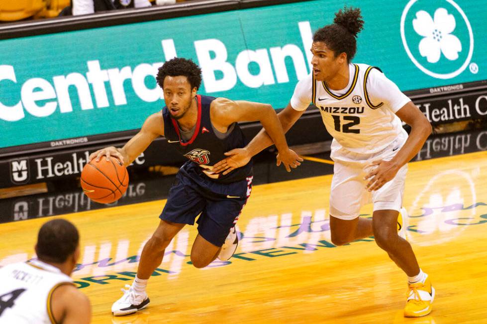 Liberty's Darius McGhee, left, drives past Missouri's Dru Smith, right, during the first half o ...