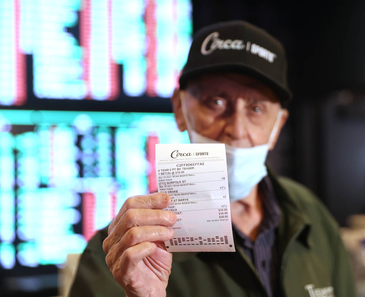 Customer Richard Seidman of Las Vegas shows the ceremonial first bet during the grand opening o ...