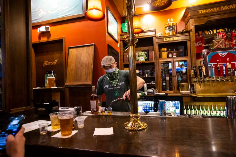 Bartender Paul Walsh Jr. prepares drinks as people gather to celebrate St. Patrick's Day at McM ...