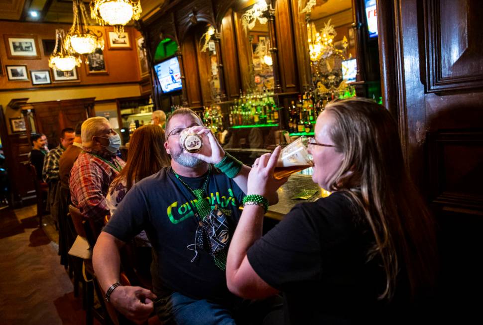 Paul Fink and Regina Gordon, both of Phoenix, drink by the bar as people gather to celebrate St ...