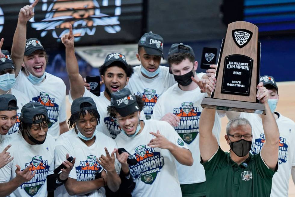 Ohio head coach Jeff Boals holds up the trophy as teammates celebrate after Ohio defeated Buffa ...