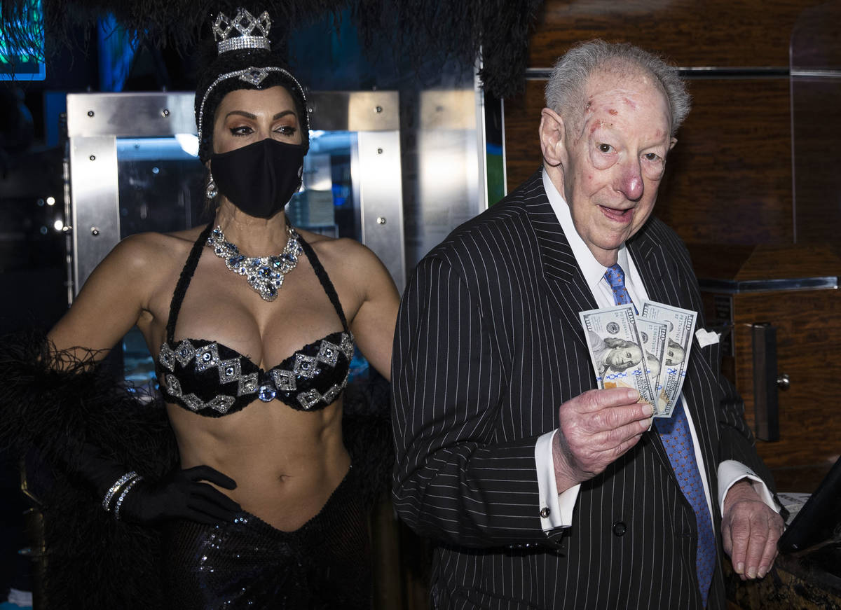 Former Las Vegas Mayor Oscar Goodman flashes $100 dollar bills as he places his March Madness w ...