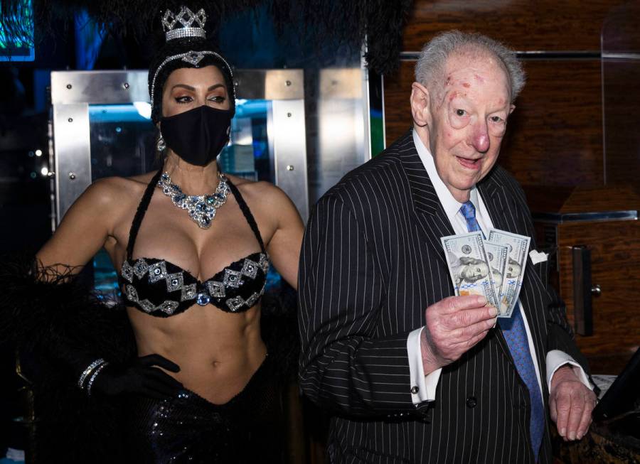 Former Las Vegas Mayor Oscar Goodman flashes $100 dollar bills as he places his March Madness w ...