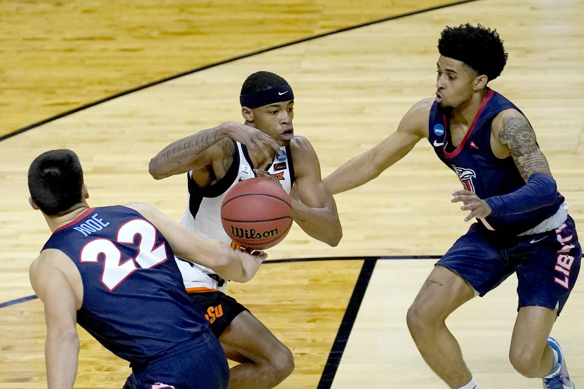Liberty's Kyle Rode (22) strips the ball from Oklahoma State guard Avery Anderson III, center a ...