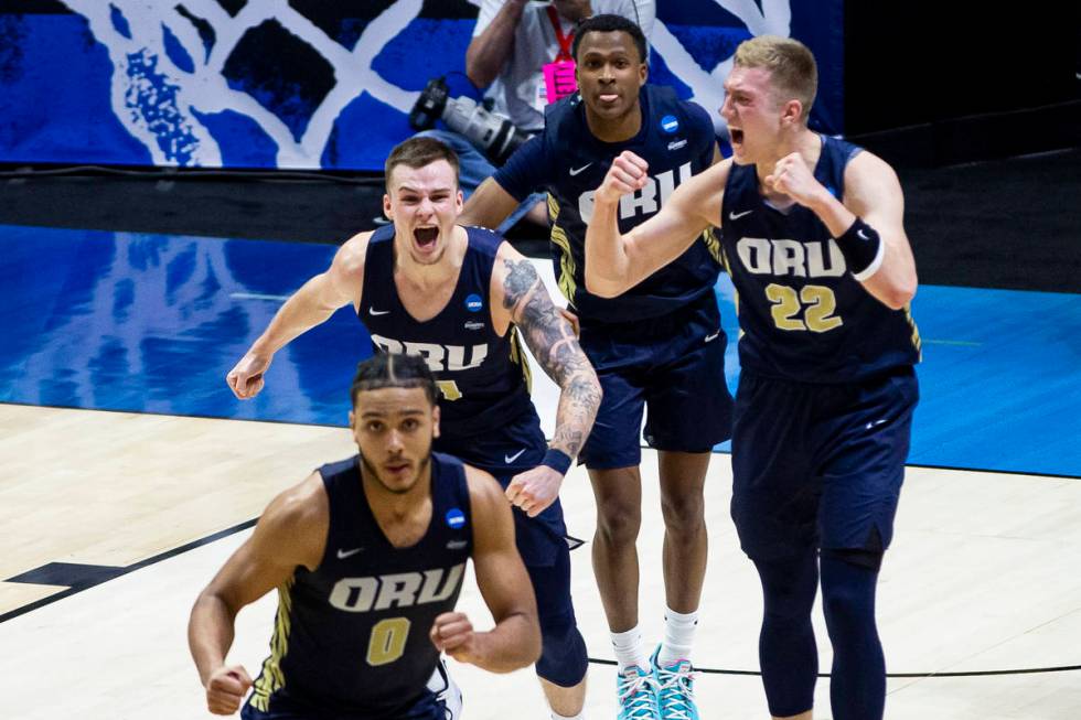 Oral Roberts players celebrate after beating Ohio State in a first-round game in the NCAA men's ...