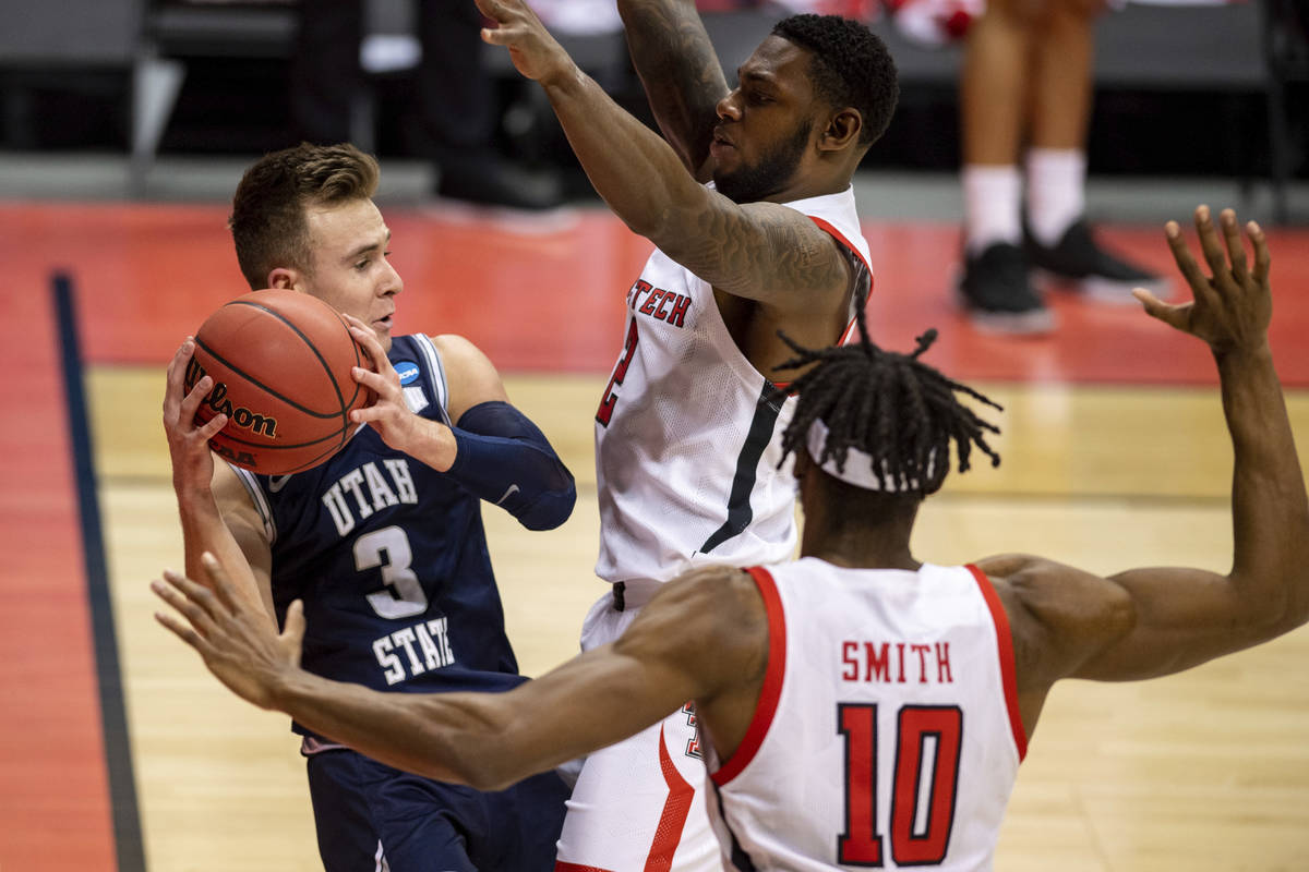 Utah State guard Steven Ashworth (3), left, is trapped along the baseline by Texas Tech guard J ...