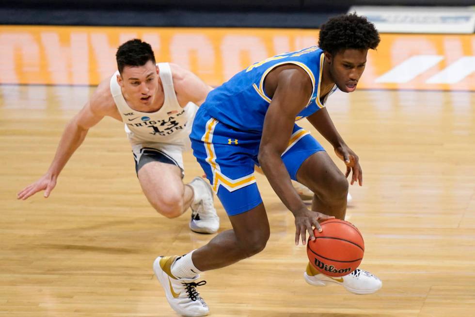 UCLA guard David Singleton (34) drives past BYU guard Alex Barcello (13) during the first half ...