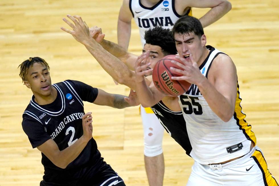 Iowa's Luka Garza (55) bobbles a pass as Grand Canyon's Chance McMillian (2) and Gabe McGlothan ...