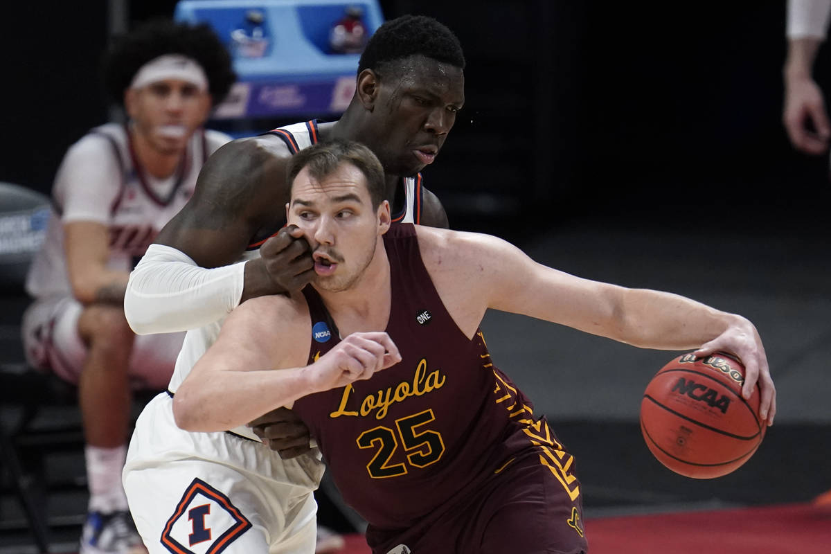 Loyola Chicago center Cameron Krutwig (25) drives on Illinois center Kofi Cockburn (21) during ...