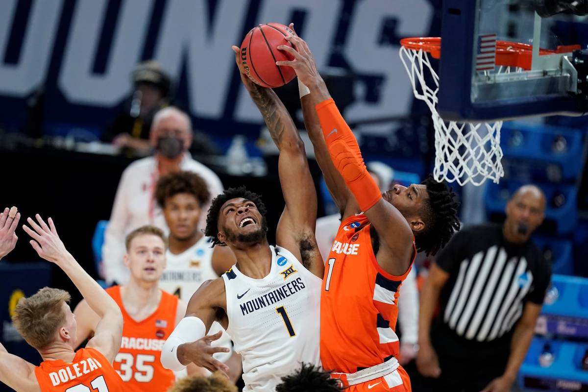 West Virginia's Derek Culver (1) has his shot blocked by Syracuse's Quincy Guerrier (1) during ...