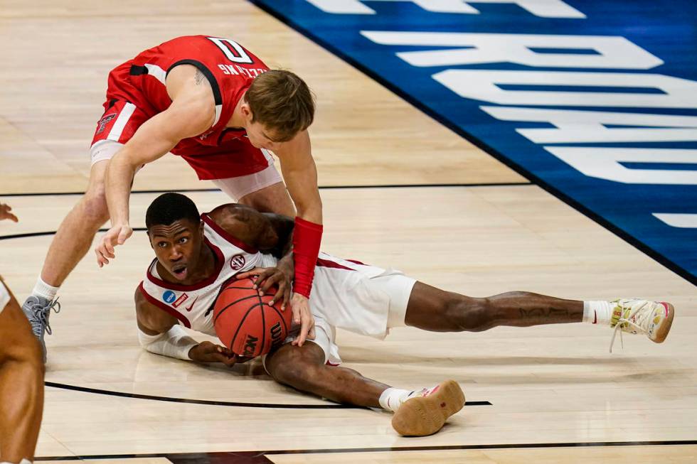 Arkansas guard Davonte Davis (4) tries to pick up a loose ball under Texas Tech guard Mac McClu ...