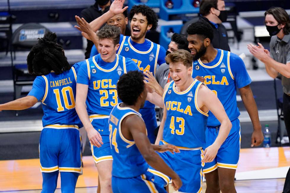 UCLA basketball players celebrate their win over BYU after a first-round game in the NCAA colle ...