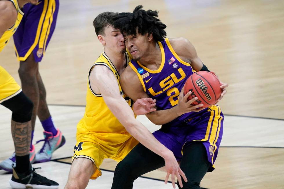 Michigan guard Franz Wagner, left, tries to steal the ball from LSU forward Trendon Watford (2) ...