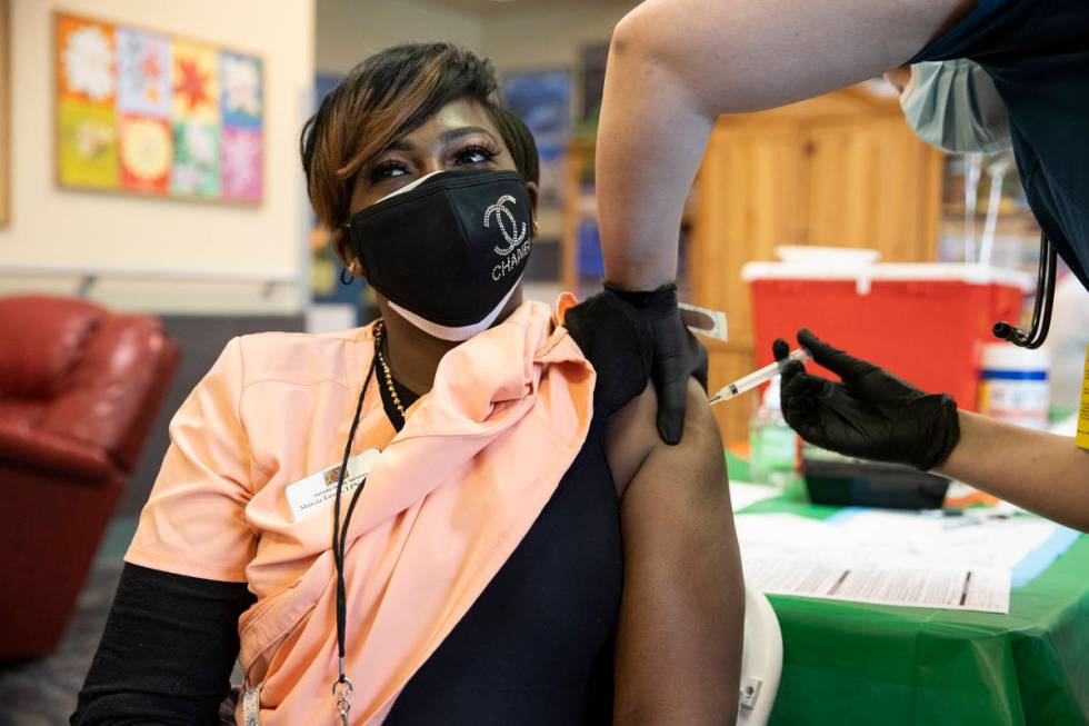 Licensed nurse Marcia Eason receives the COVID-19 vaccine from Touro University Nevada physicia ...