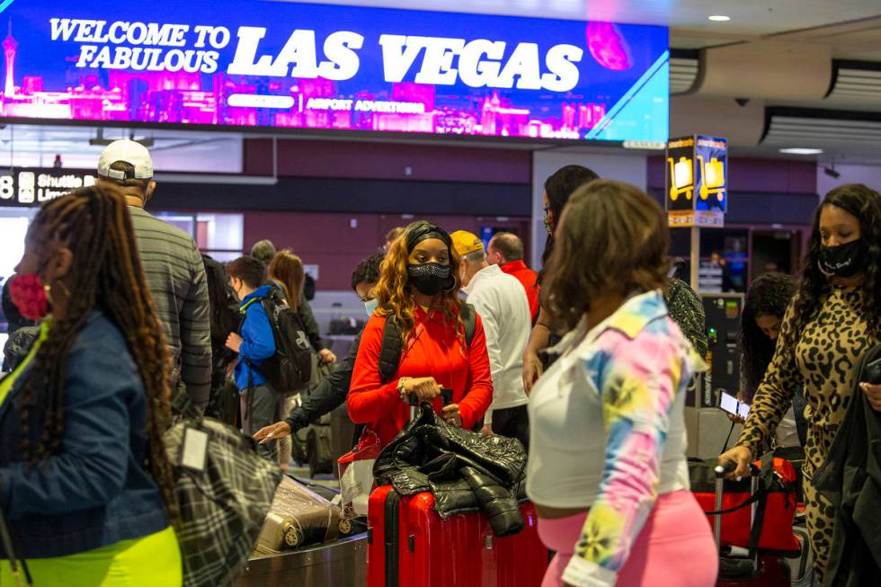 Visitors to Las Vegas, wearing personal protective equipment to prevent the spread of COVID-19, ...