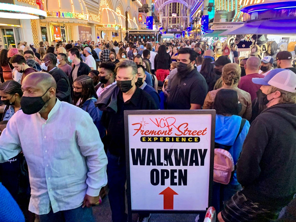 People walk along Fremont Street Experience in Las Vegas, Friday, March 19, 2021. (David Guzman ...