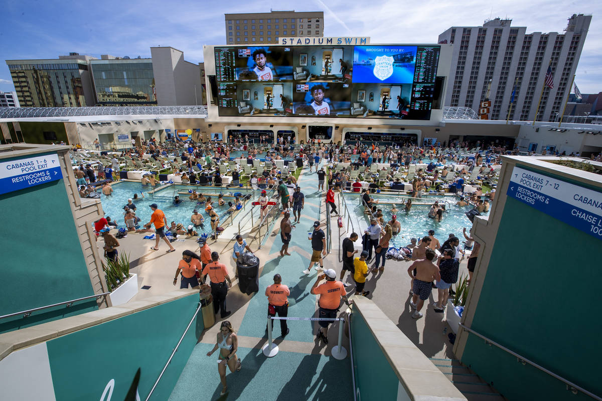 The pools and decks are crowded at Stadium Swim as March Madness is projected above at the Circ ...