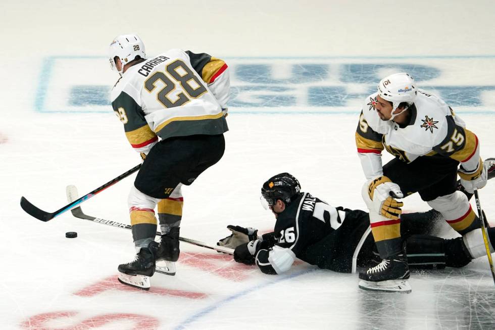 Los Angeles Kings defenseman Sean Walker, center, loses the puck as Vegas Golden Knights left w ...