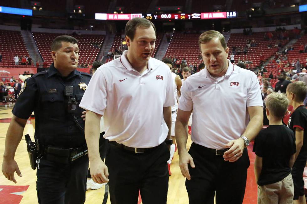UNLV's basketball head coach T.J. Otzelberger, right, and assistant coach Kevin Kruger leave th ...
