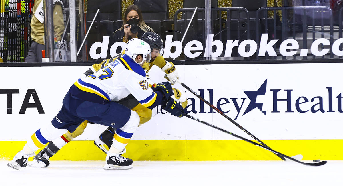 St. Louis Blues' David Perron (57) and Golden Knights' Alex Tuch (89) battle for the puck durin ...