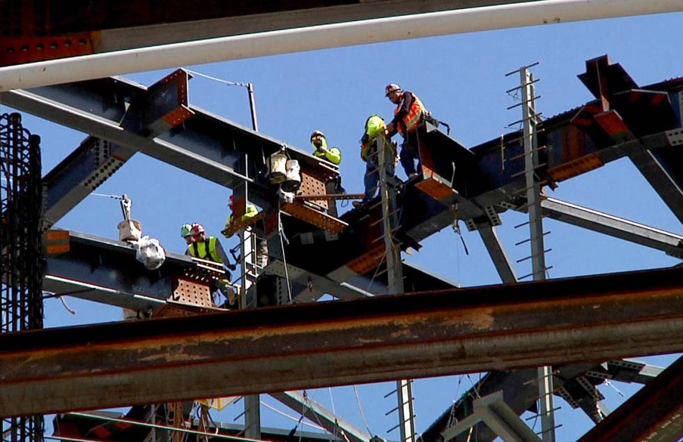 Workers match a 100 ton roof truss to the central compression ring on top of a 285-foot, 677-to ...