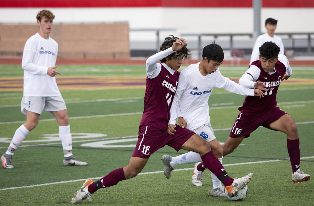 Faith Lutheran forward Ari Sirvent (14) and midfielder Preston Rincon (17) compete for the ball ...