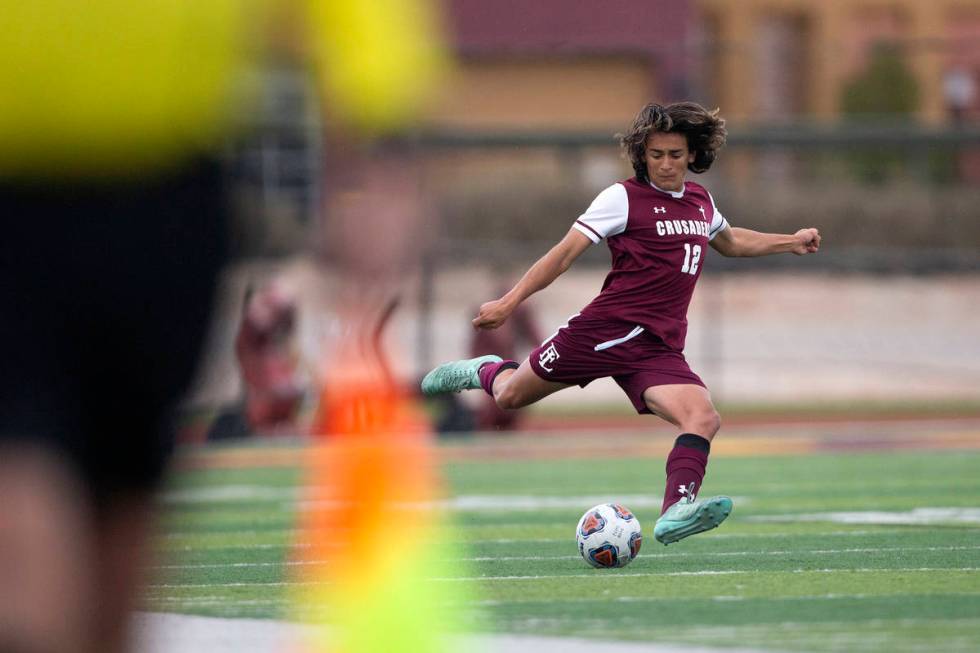 Faith Lutheran defender Logan Renteria (12) winds up to pass during a high school soccer game a ...