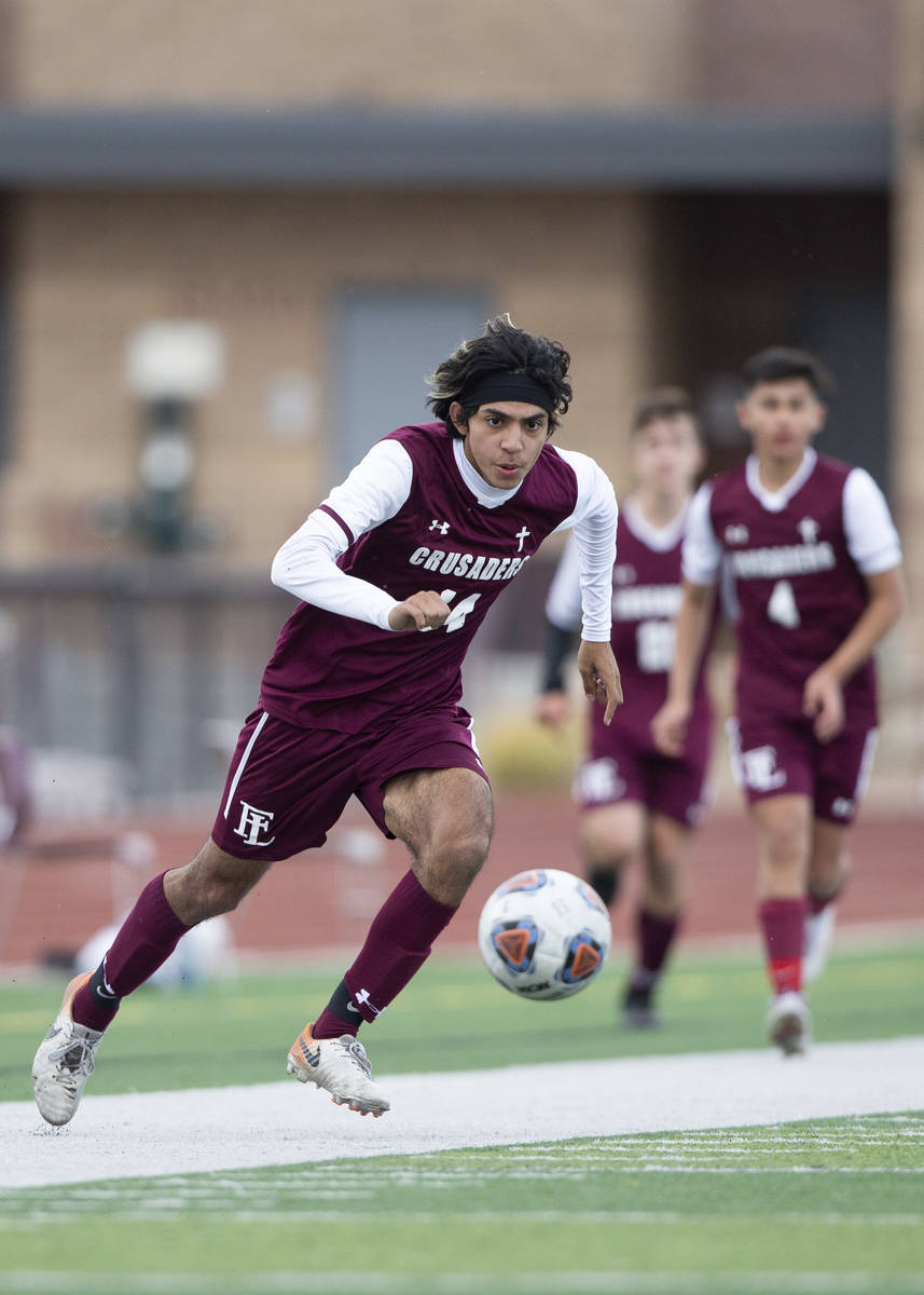 Faith Lutheran forward Ari Sirvent (14) eyes the ball during a high school soccer game against ...