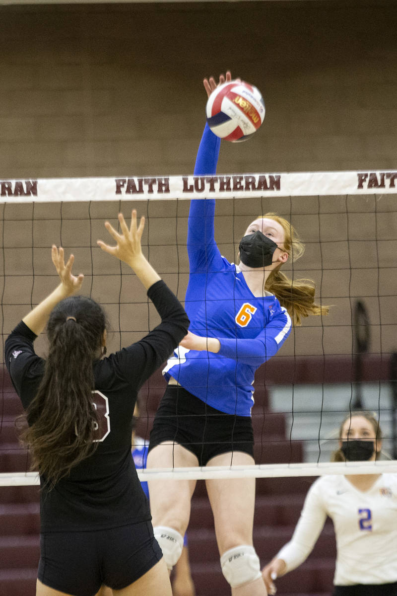 Bishop Gorman's Ashley Duckworth (6) spikes as Faith Lutheran's Bianca Richardson (6) jumps to ...