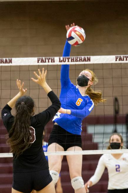 Bishop Gorman's Ashley Duckworth (6) spikes as Faith Lutheran's Bianca Richardson (6) jumps to ...