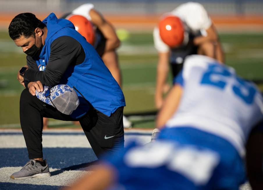 Bishop Gorman head football coach Brent Browner, left, prays with his team after practice on Fr ...