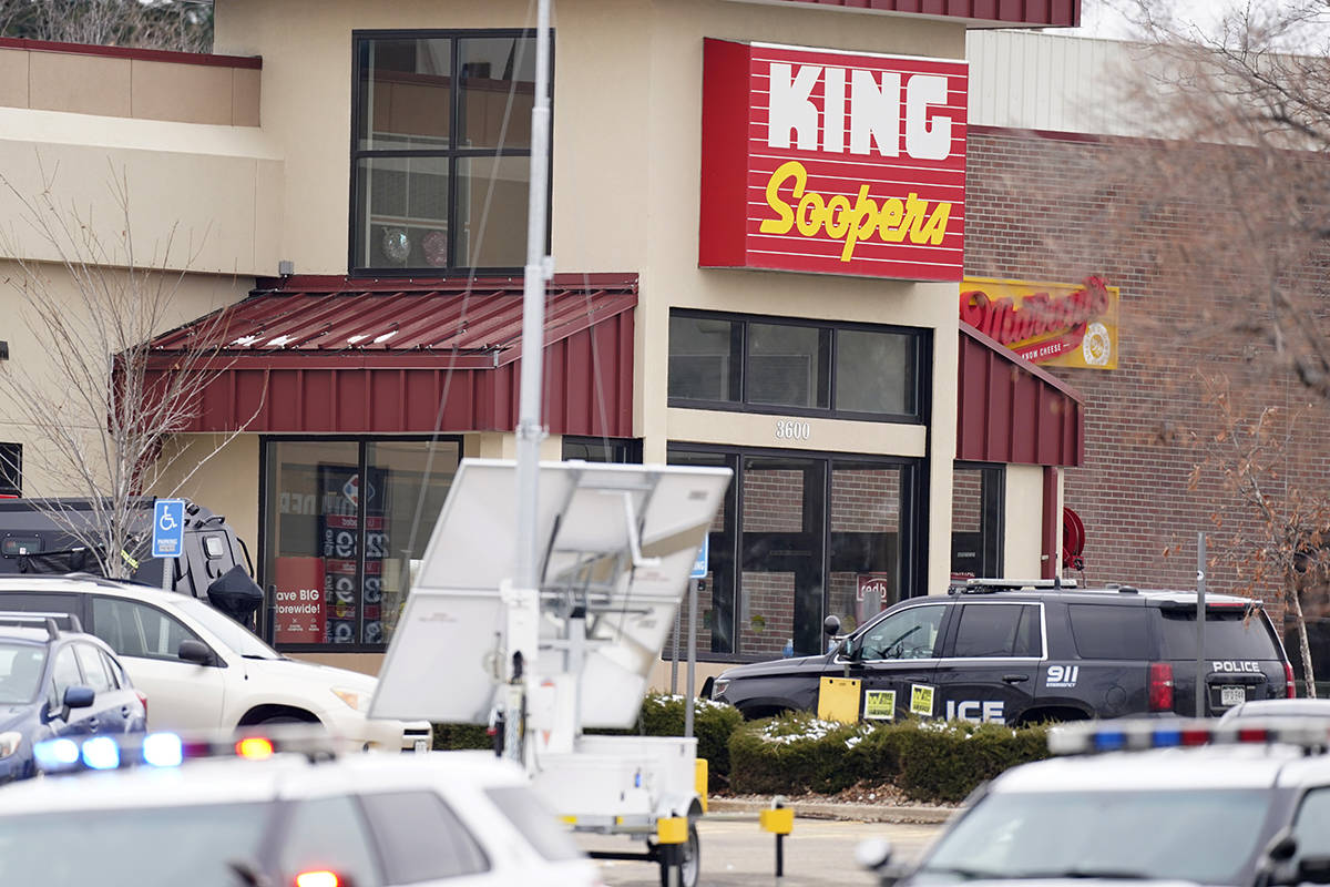 People are led out of a King Soopers grocery store after a shooting in the store, Monday, March ...