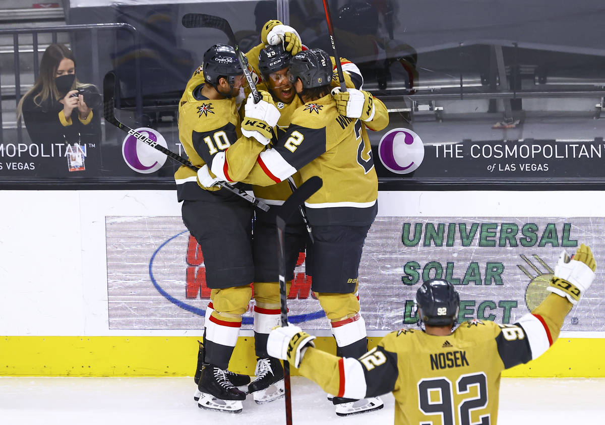 Golden Knights' Keegan Kolesar, second from left, celebrates with Nicolas Roy (10) and Zach Whi ...