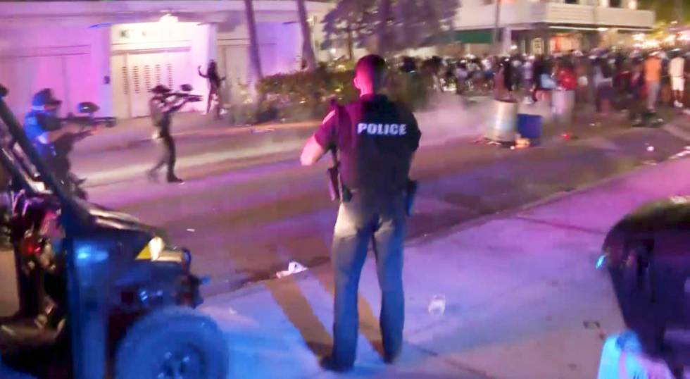 In this image taken from video, SWAT officers in bulletproof vests disperse pepper spray balls ...