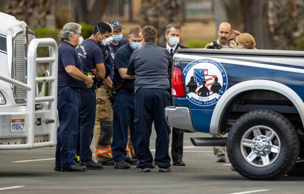 Emergency personnel look at a photo of a suspicious item on the ground at the Nevada Veterans M ...