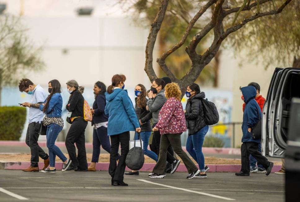 Employees are the parking lot as a suspicious item on the ground is investigated at the Nevada ...