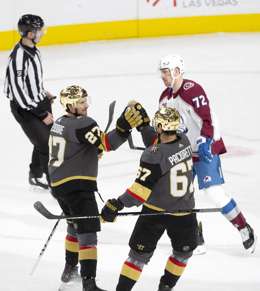 Golden Knights defenseman Shea Theodore (27) congratulates Golden Knights left wing Max Paciore ...