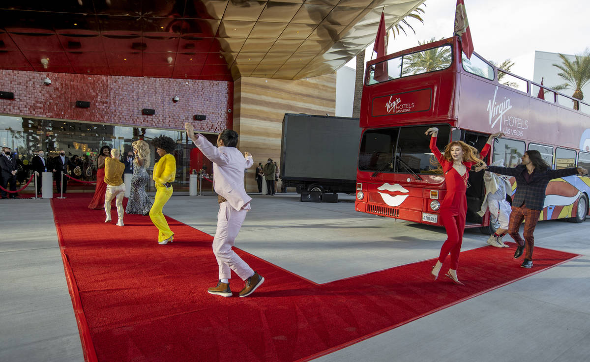 Dancers depart a double-decker bus and move up the red carpet during the Virgin Hotels Las Vega ...