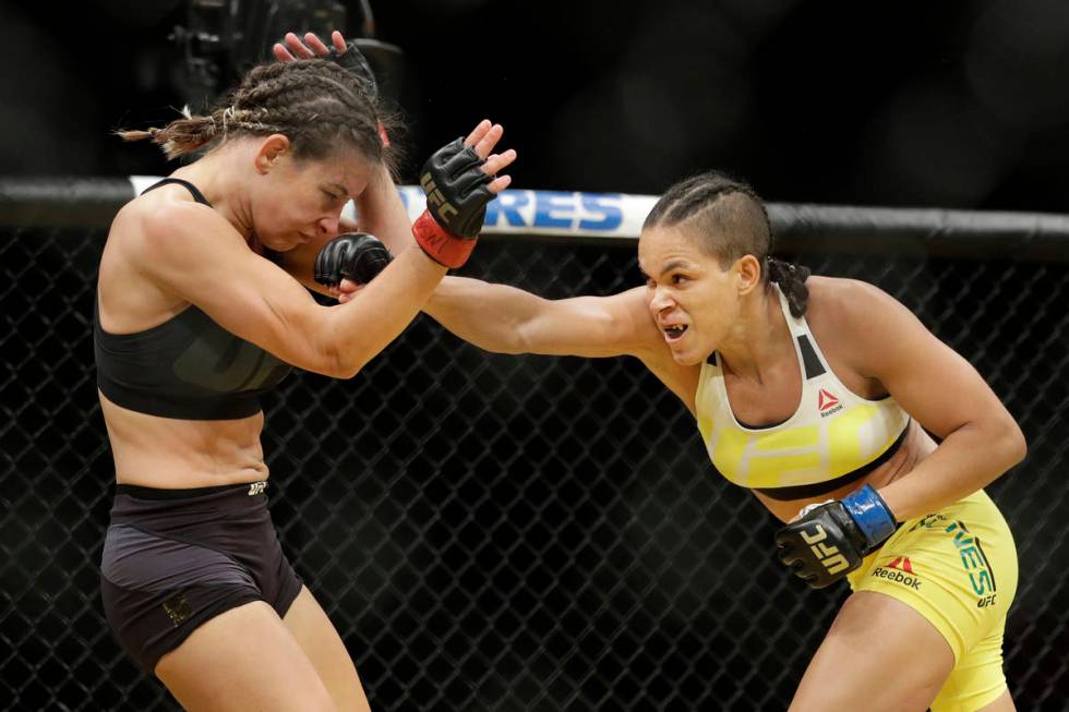 Amanda Nunes, right, hits Miesha Tate during their women's bantamweight championship mixed mart ...