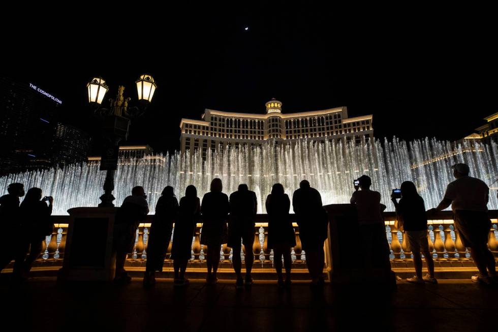 Visitors enjoy the Fountains of Bellagio show on Friday, March 19, 2021, in Las Vegas. (Benjami ...