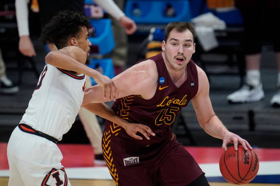 Loyola Chicago center Cameron Krutwig (25) drives on Illinois guard Jacob Grandison (3) during ...