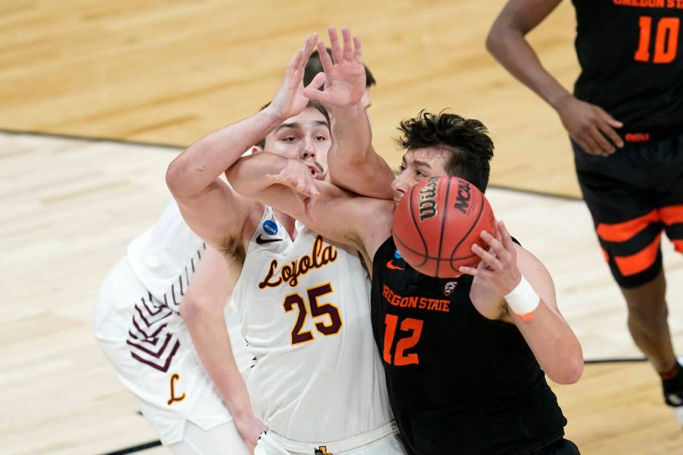 Oregon State center Roman Silva (12) drives past Loyola Chicago center Cameron Krutwig (25) dur ...