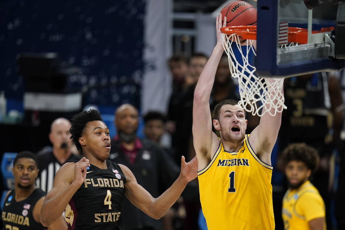 Michigan center Hunter Dickinson (1) dunks the ball ahead of Florida State guard Scottie Barnes ...