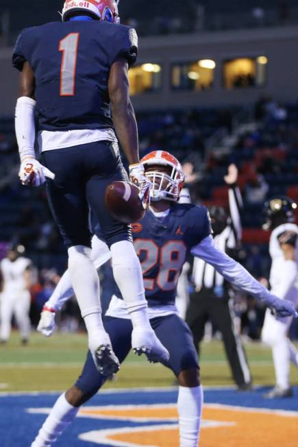 Bishop Gorman's Zachariah Branch (1) celebrates his touchdown with teammate Jeremiah Hughes (28 ...