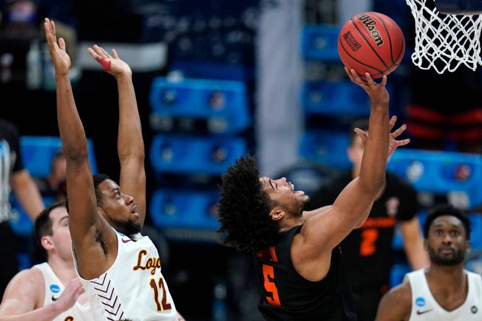 Oregon State guard Ethan Thompson (5) drives to the basket ahead of Loyola Chicago guard Marqui ...