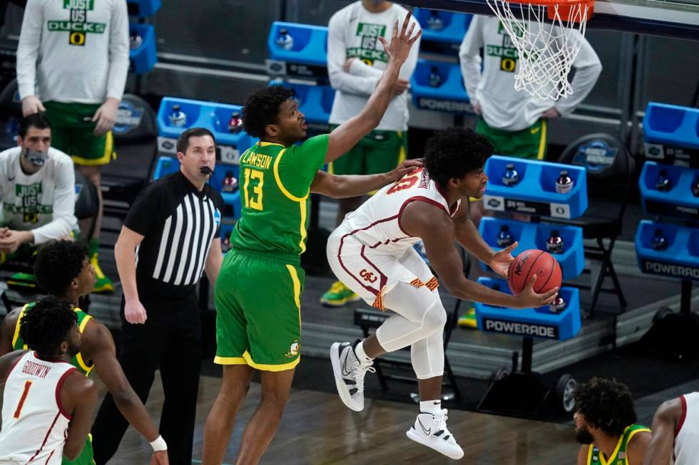 Southern California guard Ethan Anderson (20) drives to the basket in front of Oregon forward C ...
