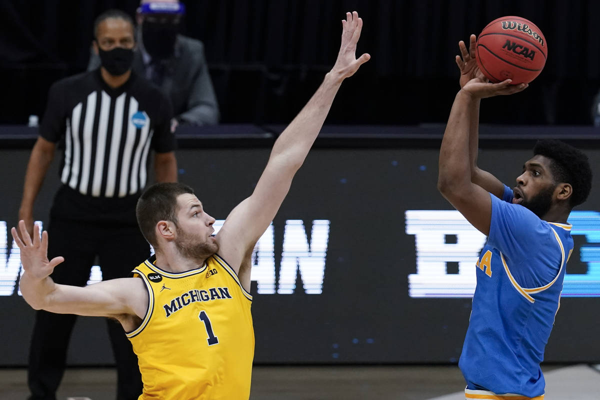 UCLA forward Cody Riley, right, shoots over Michigan center Hunter Dickinson (1) during the fir ...