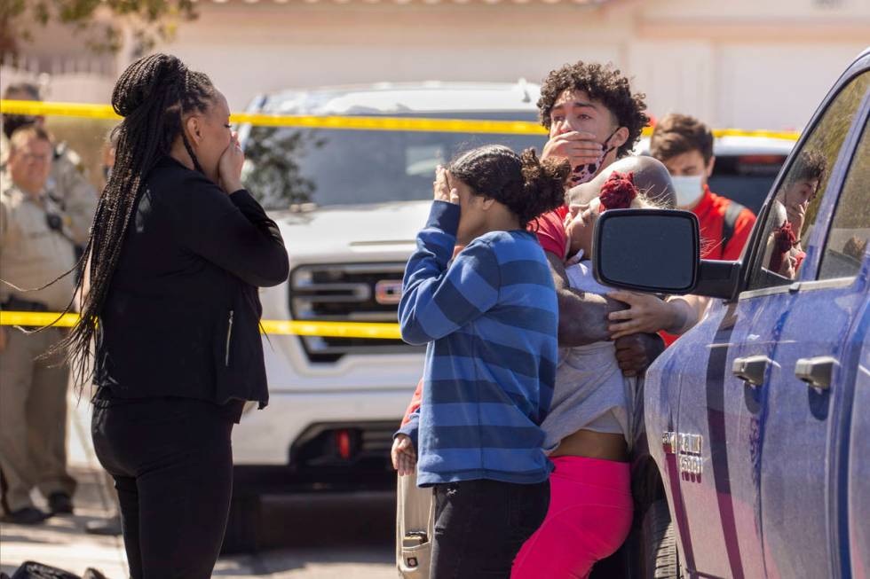 Family members console each other near where the Clark County Fire Department works a house fir ...