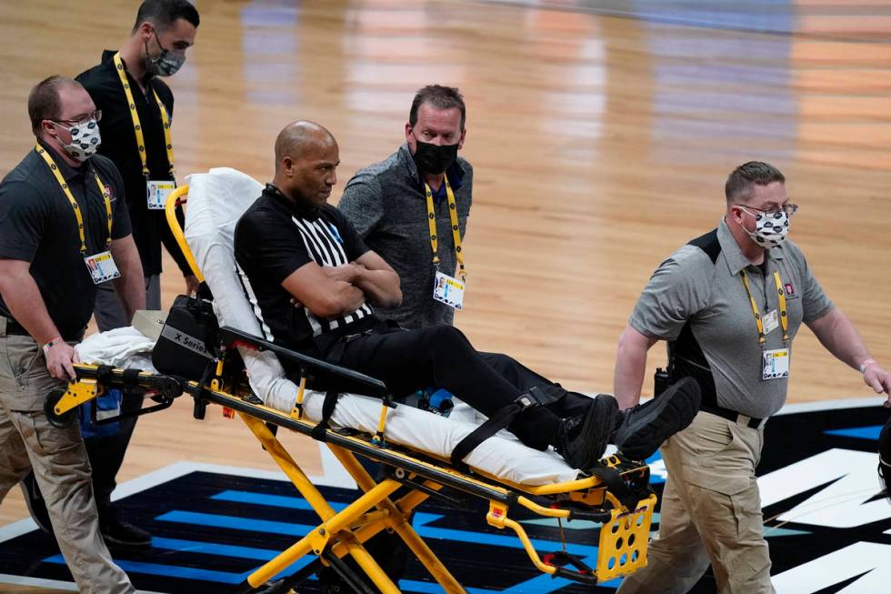 Referee Bert Smith is taken off the court on a stretcher after collapsing during the first half ...